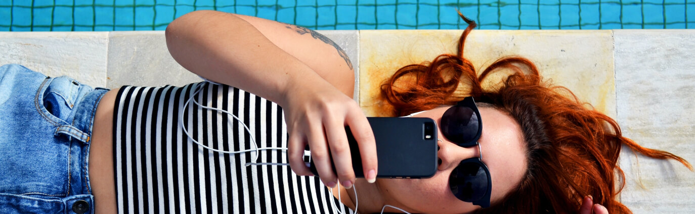 woman by pool with phone